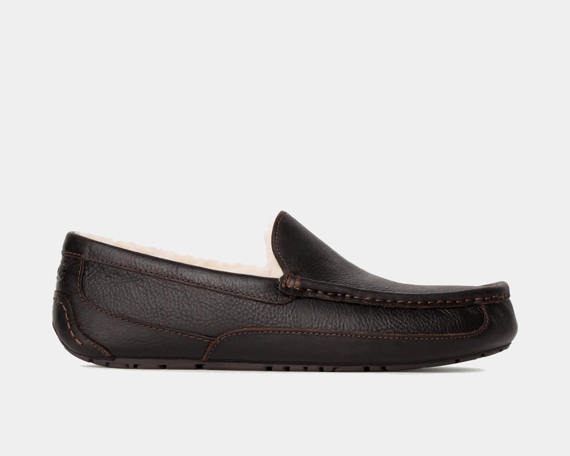 A brown UGG leather slipper with a plush lining visible from the side.