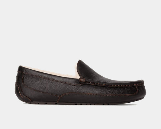 A brown UGG leather slipper with a plush lining visible from the side.