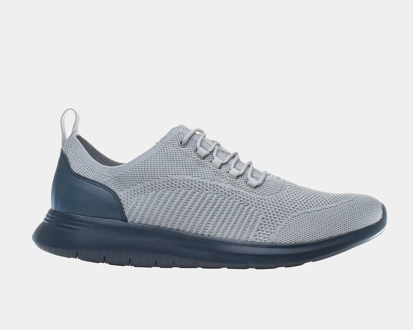 A grey dress casual style knit shoe with a leather trim and a low heel design on a flat blue sole.