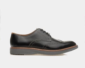 A black cushioned wingtip oxford shoe with a leather upper and a rubber outsole.