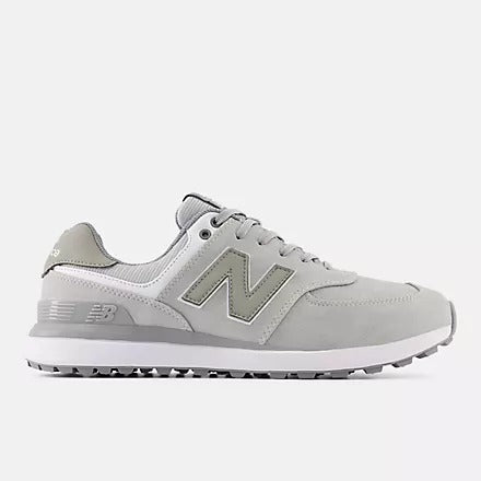 A pair of New Balance 574 Greens v2 golf shoes in light grey color, featuring a lace-up closure, the New Balance logo on the side, and a spikeless rubber outsole.